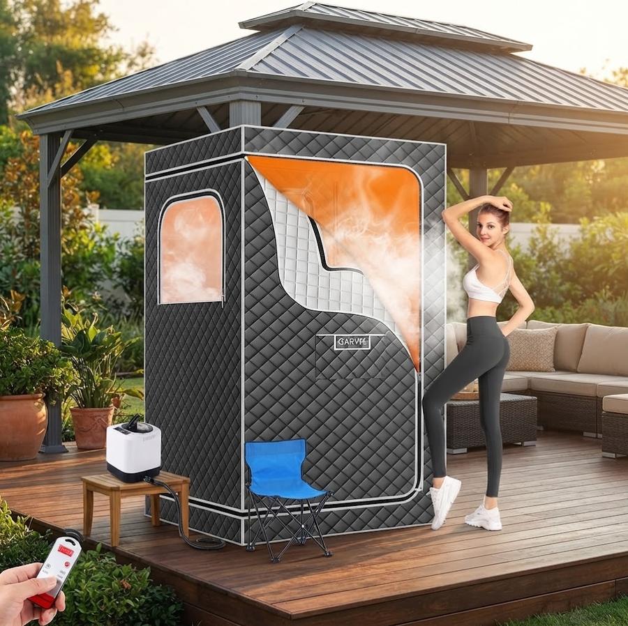 Portable sauna box set up in a spare room with towels folded beside it